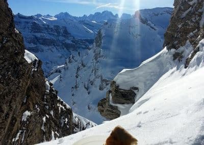 A plate of bread on snow with a mountain backdrop, showcasing a scenic winter landscape with sunlight and peaks.